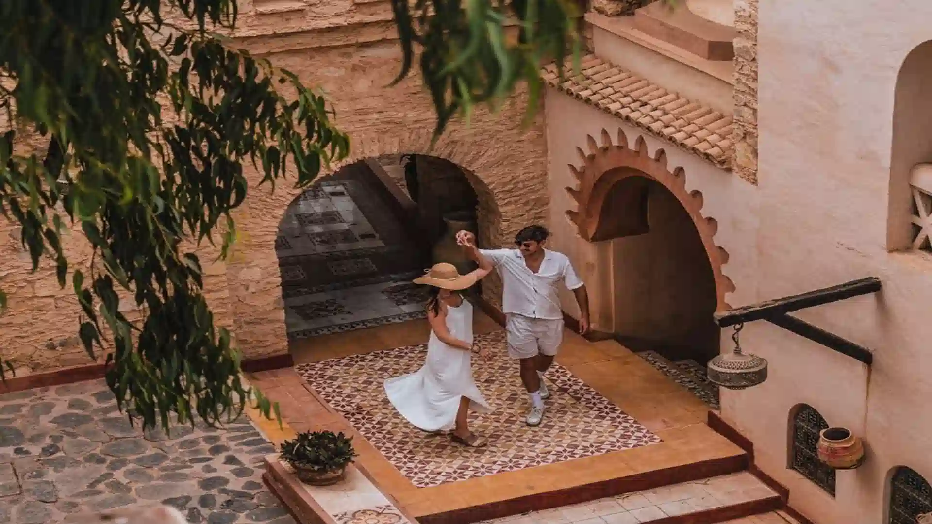 Couple enjoying a romantic moment dancing in a traditional Moroccan riad courtyard during a 4 days tour from Agadir to Marrakech