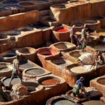 Chouara Tannery Fes Morocco — aerial view of the medieval leather tannery dye vats from rooftop terrace, Over Morocco Tours Fes guide 2026