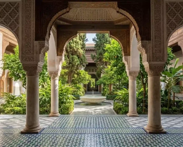 Intricate carved archways framing a lush courtyard garden with a marble fountain at Bahia Palace Marrakech.